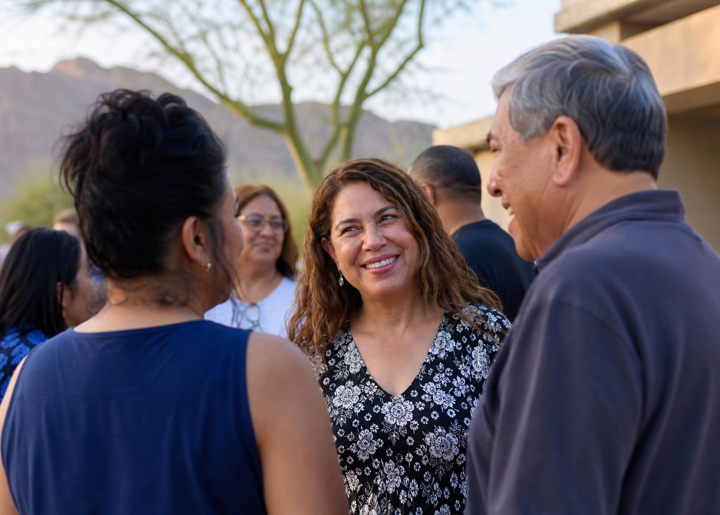Arizona voters of all ages smiling together outside a community voting center, wearing I Voted stickers